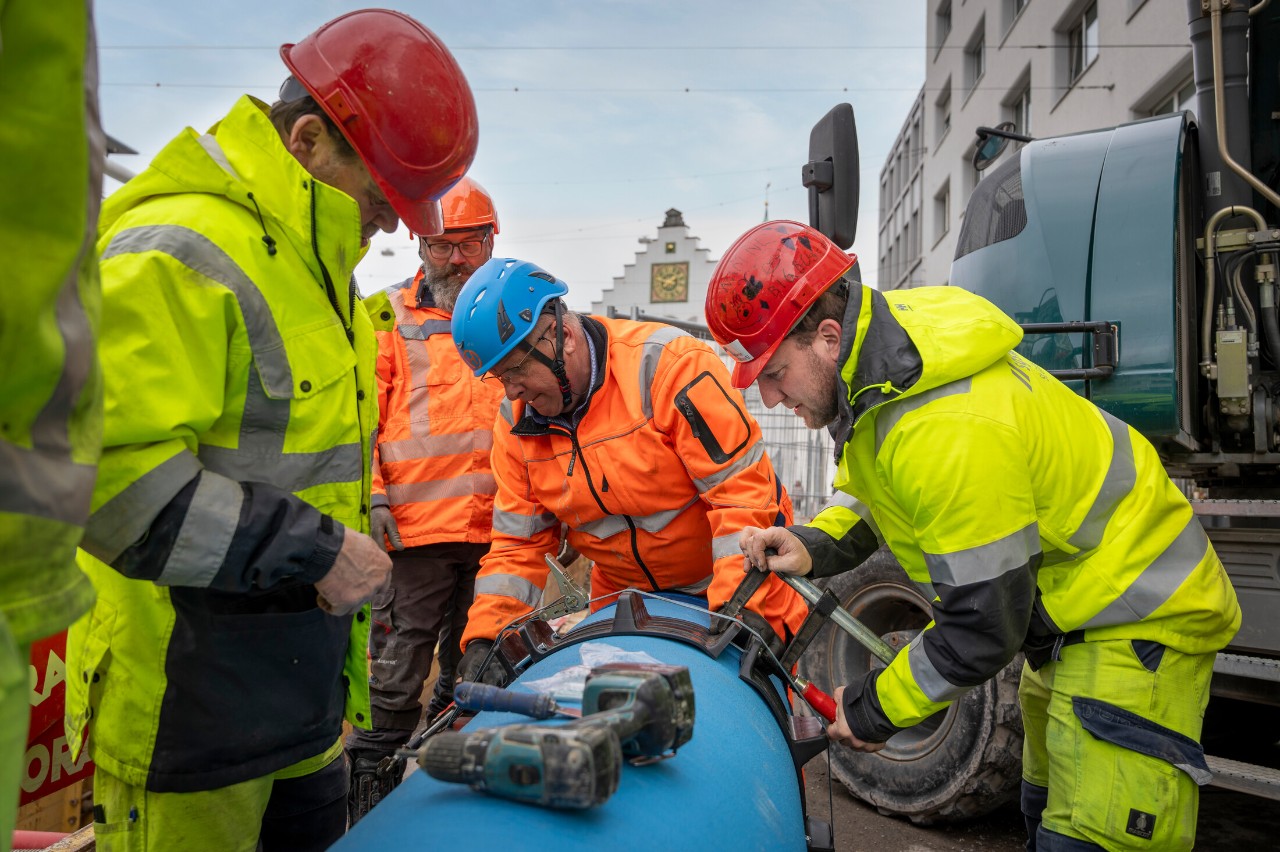 Die Monteure bereiten das Wasserrohr vor, bevor es verlegt wird.