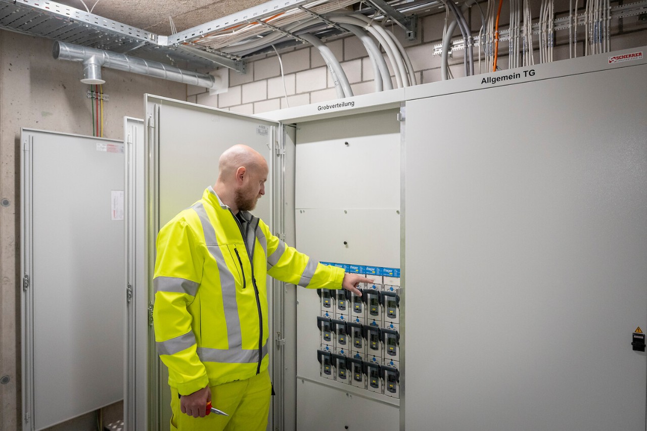 Er öffnet Türen, entfernt Abdeckungen und dokumentiert Mängel.