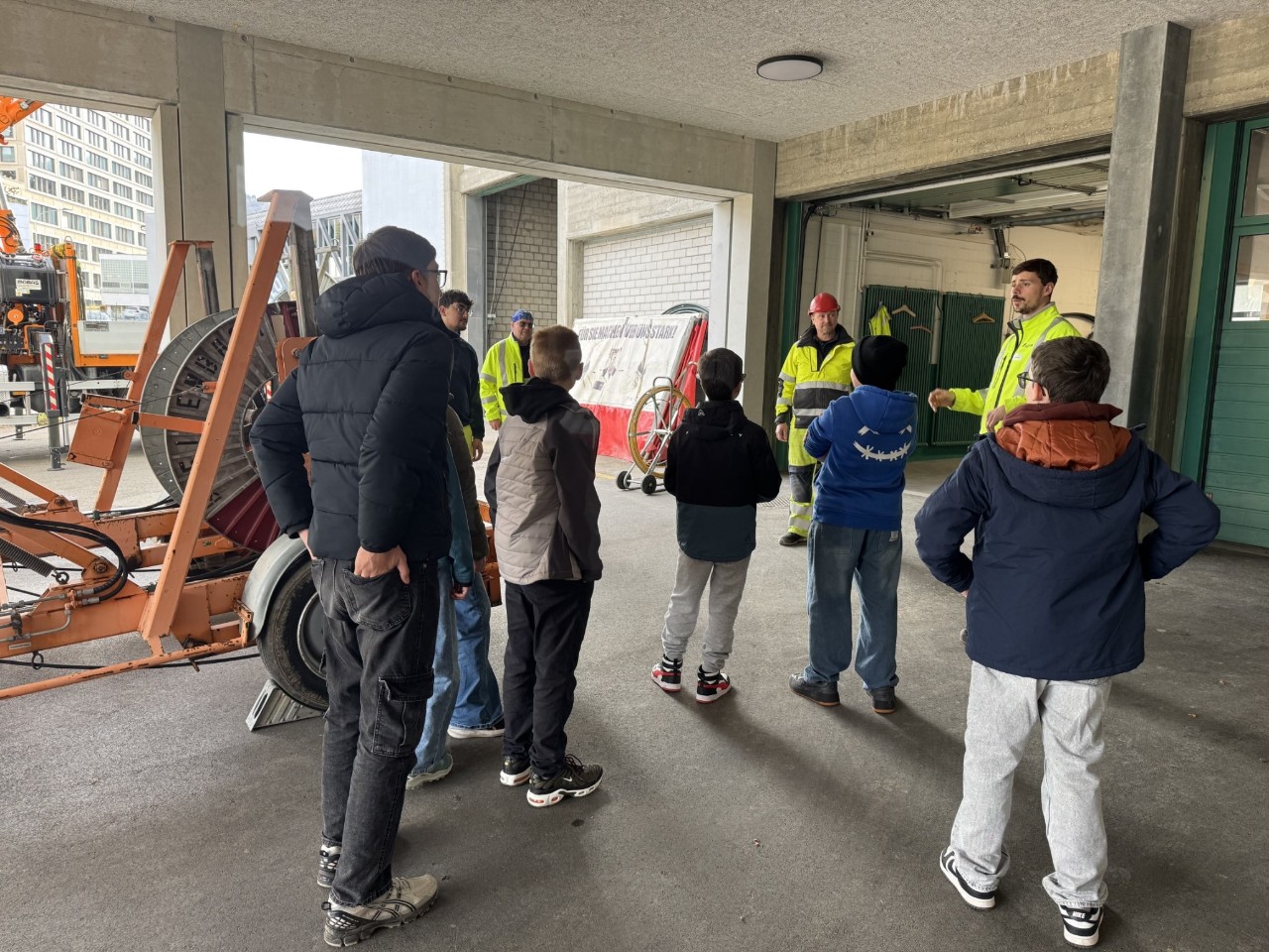 Ein Netzelektriker gibt den Schülerinnen und Schüler eine kurze Einführung in die praktische Arbeit, bevor sie selbst Hand anlegen dürfen.